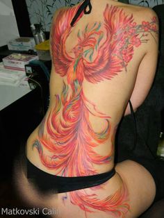 the back of a woman's body with tattoos on her stomach and an orange bird