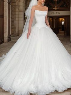 a woman in a white wedding dress is posing for the camera