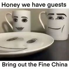 two coffee mugs with faces drawn on them are next to a plate that says, honey we have guests bring out the fine china