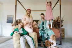 a group of people sitting on top of a bed in a room with two children