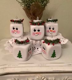 a group of snowmen sitting on top of a white table next to a potted plant