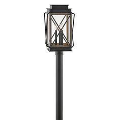 an outdoor post light with a cage on the top and two candles in the middle