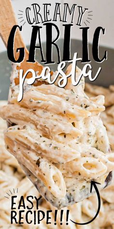 creamy garlic pasta in a skillet being held by a wooden spoon with text overlay