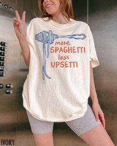 Featuring the cheeky phrase "More Spaghetti, Less Upsetti," this vintage inspired graphic tee is perfect for pasta lovers who know that carbs are the cure for anything. We use professional quality DGT printing on all our apparel. Direct-to-garment, or DTG, is a high quality printing method that sprays ink directly onto the garment so there is no peeling or cracking. This fabulous graphic will be printed on a Comfort Colors Unisex T-Shirt. Please refer to the size charts in the images for the bes Food Graphic Tee, Colorful Graphic Tees, Funny T Shirts For Women, Food Shirts Graphic Tees, Funny Cricut Shirts, Funny T-shirts, Meredith Core, Funny Sayings On Shirts, Butter Branding