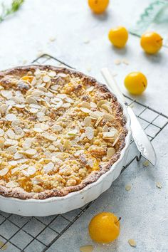 a pie sitting on top of a cooling rack next to oranges