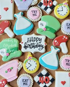 decorated cookies are arranged in the shape of dresses, hats, and clocks on a table