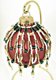 a red ornament with green and white beads