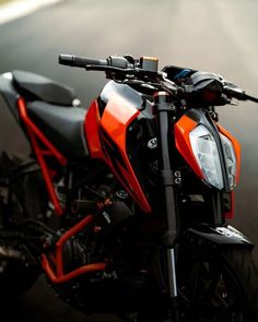 an orange and black motorcycle parked on the street