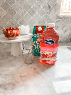 the ingredients for making strawberry water are displayed on a marble countertop in front of a window