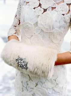 a woman wearing a white dress and holding a fur purse