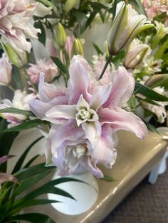 pink and white flowers in a vase on a table