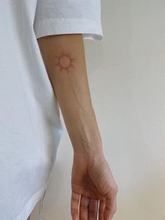 a person with a small sun tattoo on their arm