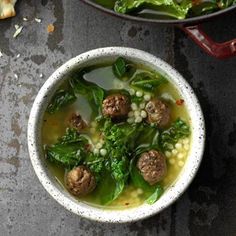 two bowls of soup with meatballs and spinach