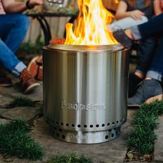 people sitting around a fire pit on the ground