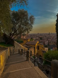 stairs leading up to the top of a hill with trees and buildings in the background