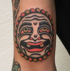 a close up of a person's arm with a tattoo on it and a clown face