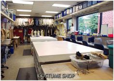 the inside of a clothing store with tables and chairs