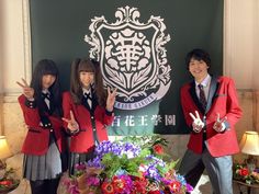 three girls in school uniforms posing for the camera with one girl giving the peace sign