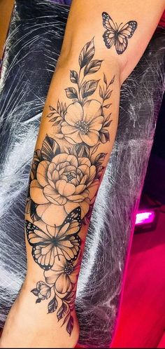 a woman's arm with flowers and butterflies on it