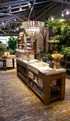 a kitchen island made out of pallets in a garden store with plants on the shelves