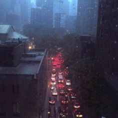 a city street filled with lots of traffic on a foggy day in the evening