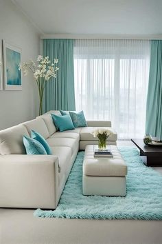 a living room with white furniture and blue curtains on the windowsill, along with a large rug