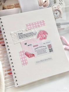 a pink and white baby book with bunny ears on it, next to other items