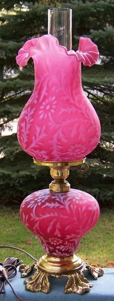 a pink vase sitting on top of a blue table