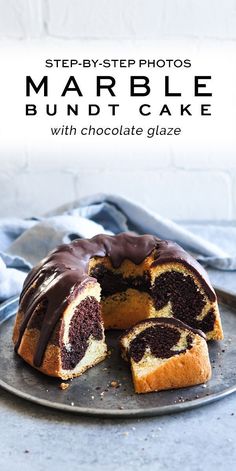 a marble bundt cake with chocolate glaze is cut in half on a plate