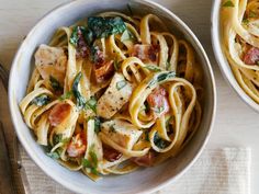 two bowls filled with pasta and meat on top of a table