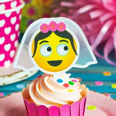 a cupcake with a bride's face on it sitting on top of a pink plate