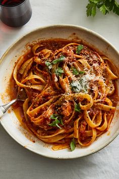 a white bowl filled with pasta and sauce