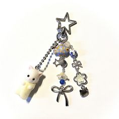 a keychain with a teddy bear, star and other charms attached to it