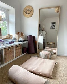 a living room filled with lots of furniture next to a large mirror on the wall