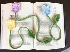 an open book with crocheted flowers on it