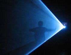 a man standing in front of a blue light