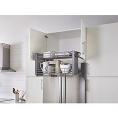 a kitchen with stainless steel appliances and white cupboards on the wall, in front of an oven