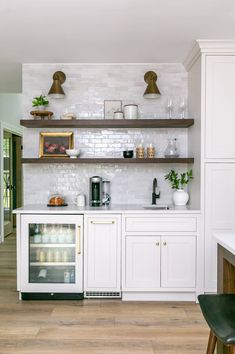 a kitchen with white cabinets and wooden floors