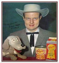 a man in a suit and tie with a toy dog next to him