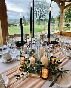 the table is set with candles and plates