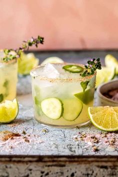 two glasses filled with cucumber, lime and mint cocktails on a tray