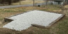 there is gravel on the ground in front of a fenced off area with grass growing out of it