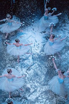 several ballerinas in blue tutus and white dresses are dancing through water with bubbles