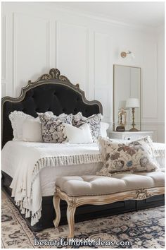 a white bed with black headboard and foot board sitting on top of a rug