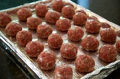 some meatballs are on a baking sheet and ready to be cooked in the oven