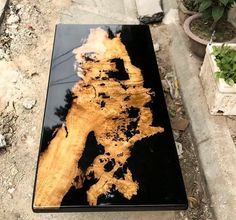 a wooden table with black and gold paint on it