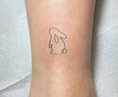 a small tattoo on the ankle of a person with a dog's head drawn on it