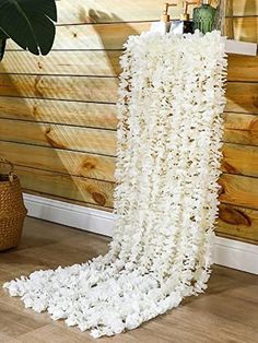 a white rug with flowers on it in front of a wooden wall