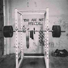 a black and white photo of a squat rack with two barbells on it