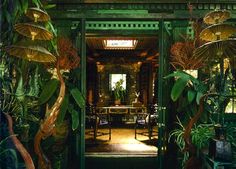 an open door leading to a dining room with lots of plants